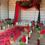 Gothic engagement setup with black and red roses, black candles, and custom romantic decor by Moonlit Adore.