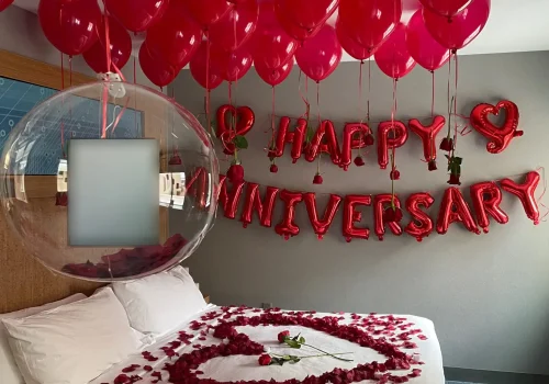 Romantic hotel room setup with red balloons and rose petals for an anniversary celebration