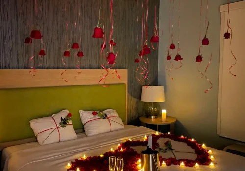 Romantic hotel room with hanging roses, champagne, and heart-shaped petals